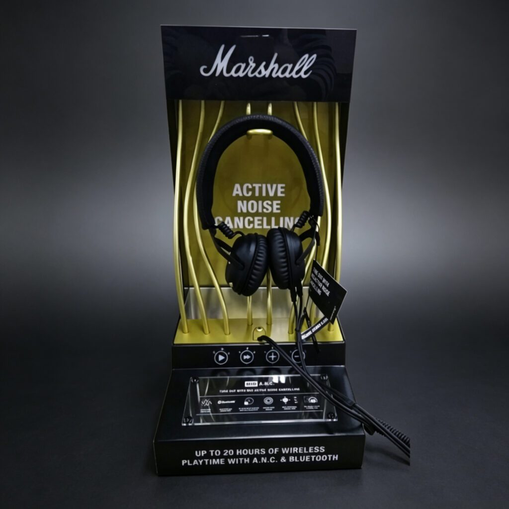 headphone counter-top display with black and gold design, showcasing ANC Bluetooth headphones in retail packaging