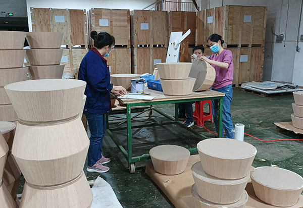 Workers assembling wooden retail display components at GP Metalwares factory, Dongguan