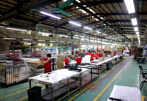 GP Metalwares factory assembly line with workers assembling metal retail display racks in a well-organized production facility
